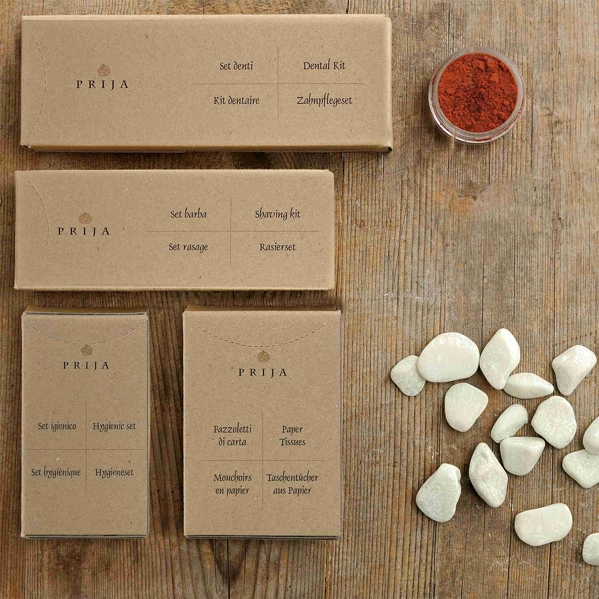 Cutiuțe pentru igienă personală hotelieră așezate pe o masă din gama de cosmetice hoteliere Prija