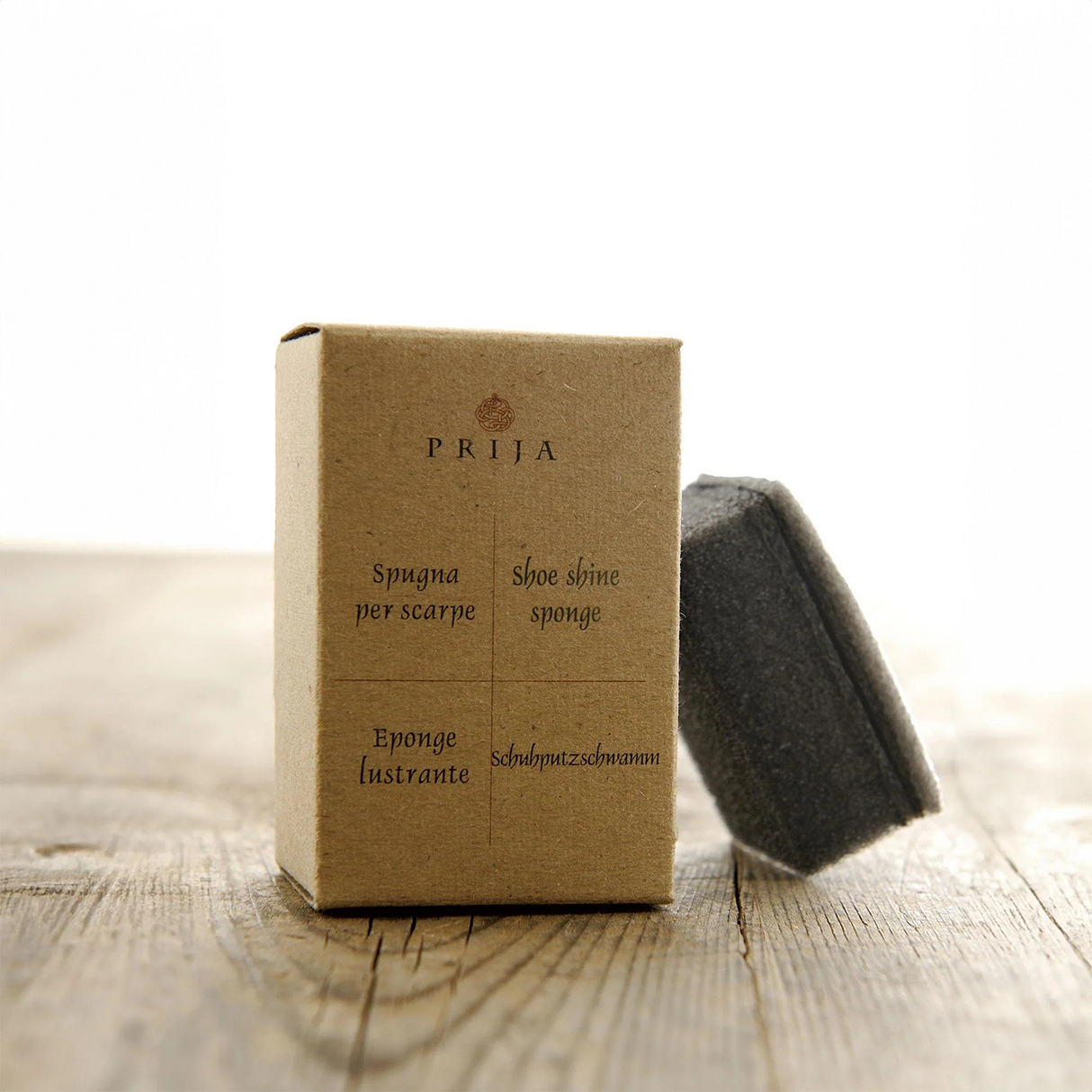 Burete hotelier pentru pantofi, din gama de cosmetice hoteliere prija așezat lângă cutiuța de ambalare, pe masă